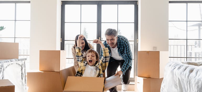 A family enjoys a playful moment with their moving boxes, courtesy of the efficient services provided by Dulles VA interstate movers.