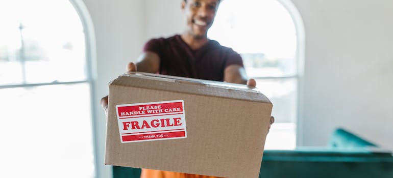 one of the interstate movers Virginia residents trust holding a box labeled fragile