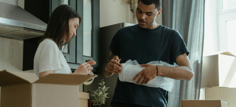 a man and a woman packing and talking about the guide to local moving