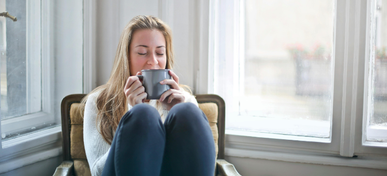 a woman drinking out of a cup