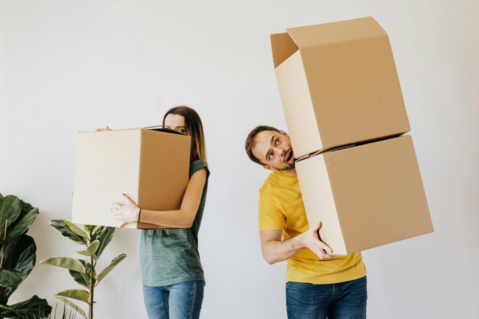 man and woman carrying cardboard boxes