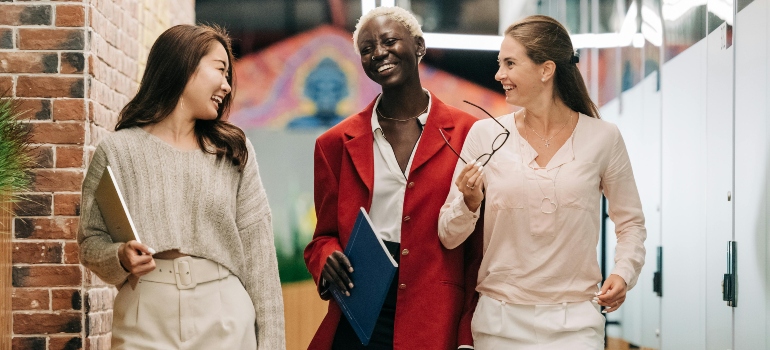 Three women smiling in the office after seeing how easy the process of moving your office IT Infrastructure successfully is.