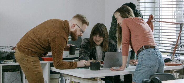 three people standing around the table talking about global mobility and retention