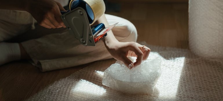 a person taping a wrapped plate 