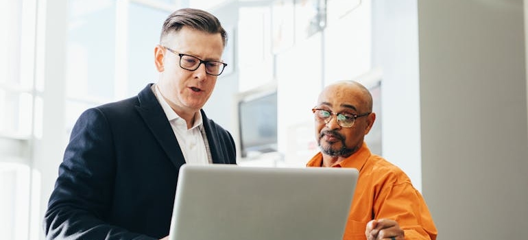 Man Using Silver Laptop Beside Another Man