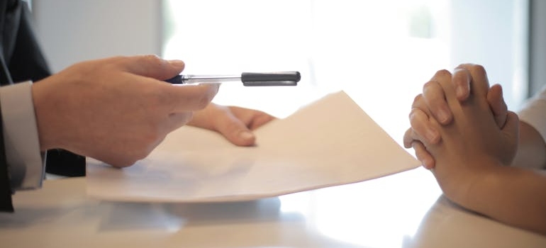  businessman giving contract to woman to sign