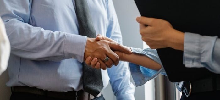 Man and woman shaking hands in office