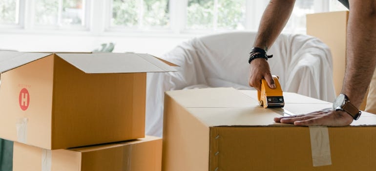 one of the Rockville movers taping a box 