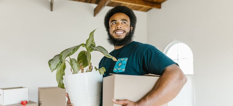 a mover holding a plant and a box 