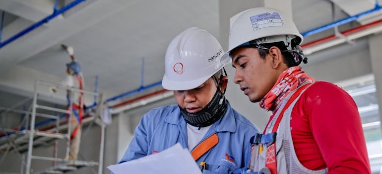 two construction workers looking at papers 