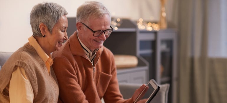 Older couple looking at homes on a tablet and talking about downsizing in Washington