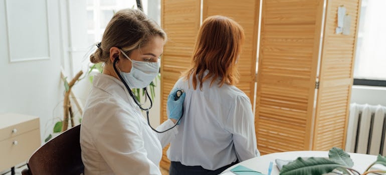 Woman in White Long Sleeve Shirt and Blue and White Face Mask