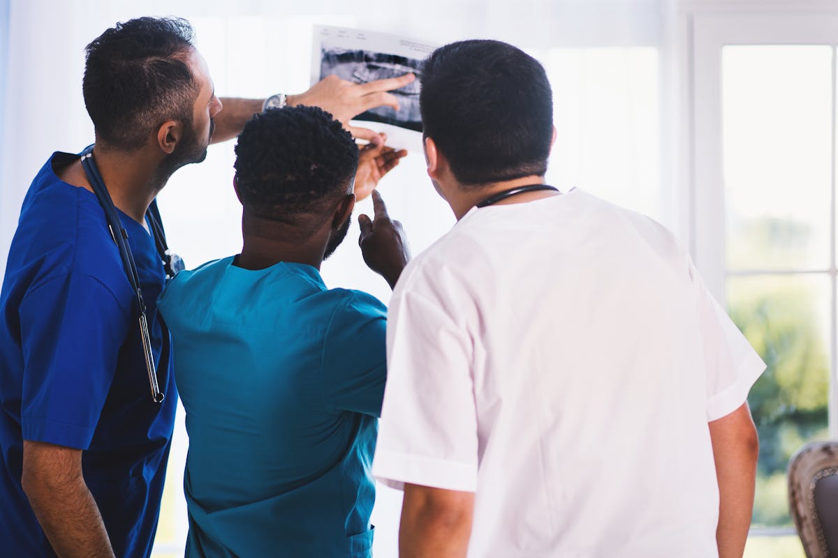 Three doctors Looking at X-ray Result