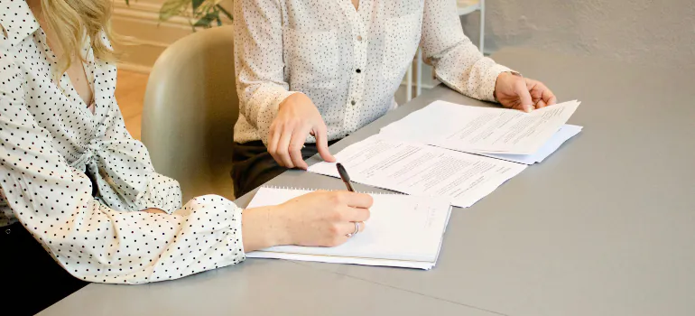 two women handling paperwork in order to establish a residency after moving abroad